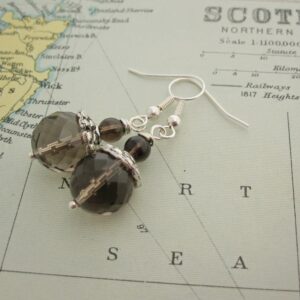 Drop earrings with facet cut smokey quartz and silver plated bead caps. Designed and created in the Isle of Skye.